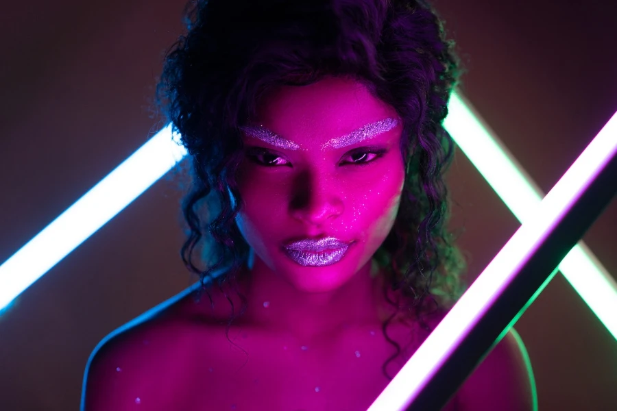 Woman in glitter makeup with purple light reflection
