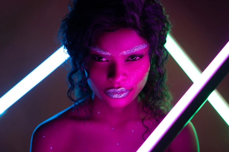 Mujer en maquillaje brillante con reflejo de luz púrpura