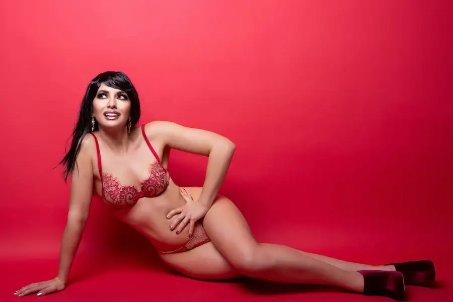 Woman in neutral-red underwear posing on a red surface