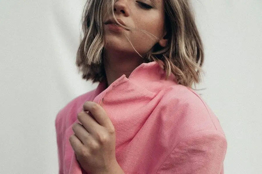 Woman posing in a pink tailored coat