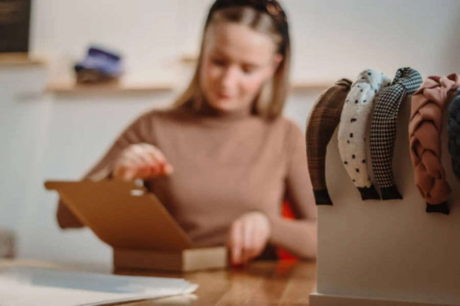 Woman sitting at table with box of fabric headbands