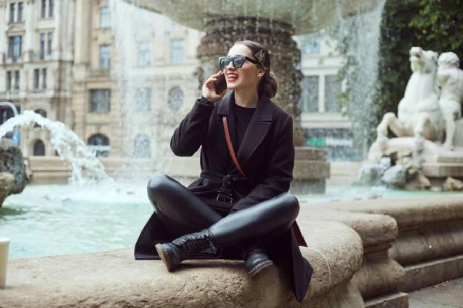Woman sitting by a fountain wearing black leggings