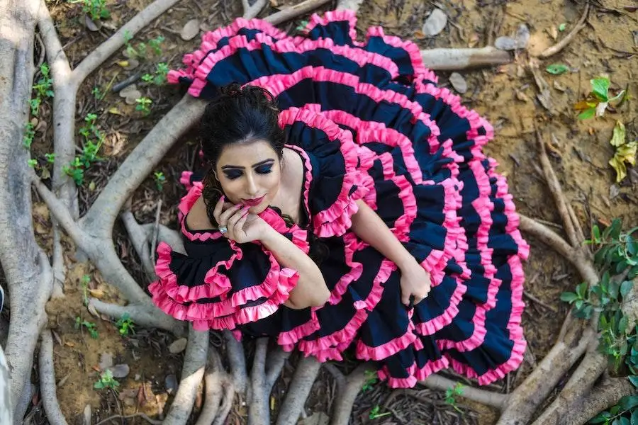 Femme assise sur des branches vêtue d'une robe grunge romance