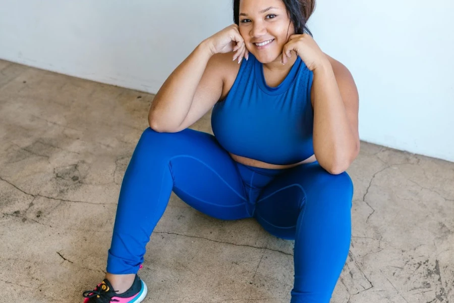 Woman sitting on the floor while wearing blue leggings