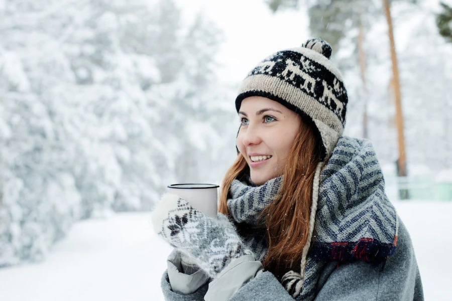 Woman wearing a black and white knit earflap beanie hat