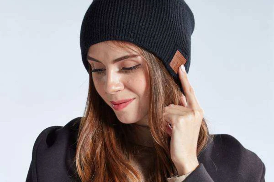 Woman wearing a black knit Bluetooth beanie hat