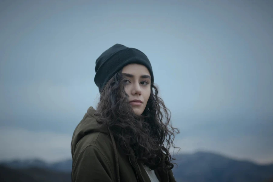 Woman wearing a black knit cuffed beanie hat