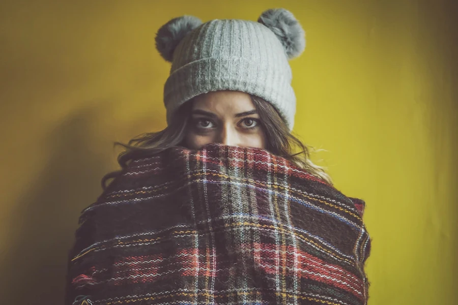 Woman wearing a gray knit pom-pom beanie hat