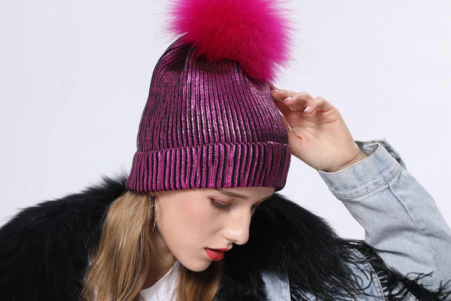 Woman wearing a pink knit metallic beanie hat