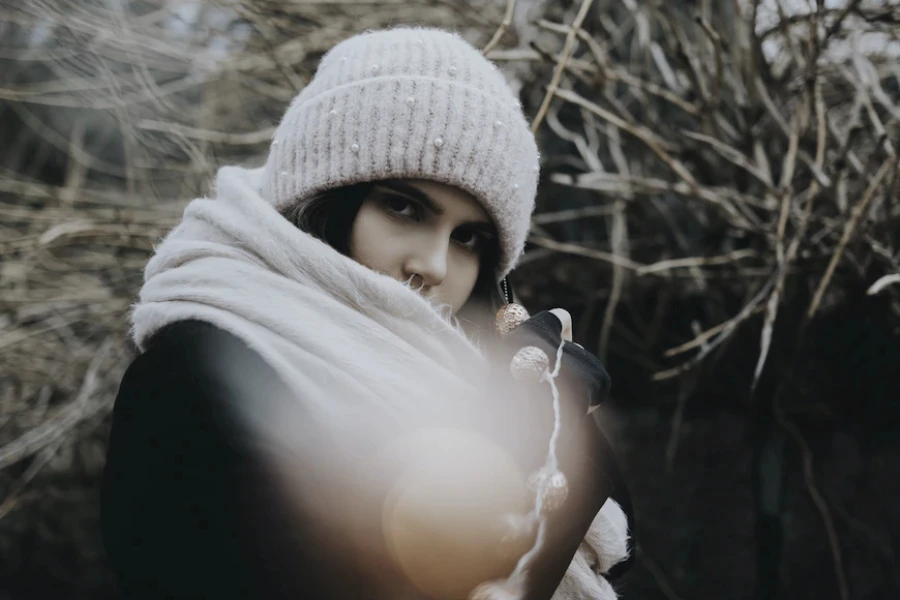 Mujer con un gorro de punto color marfil adornado con perlas de imitación