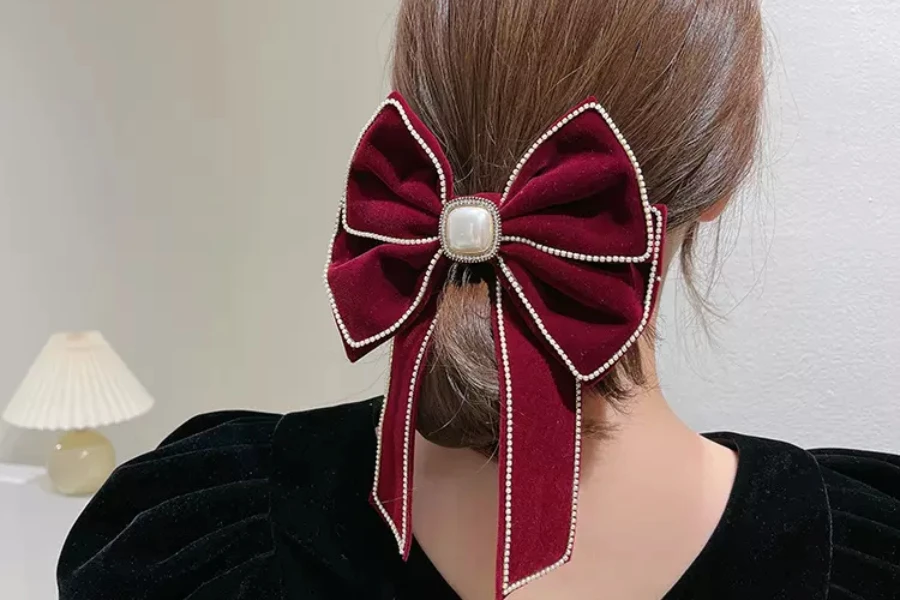 Woman wearing red velvet hair clip with pearl in center