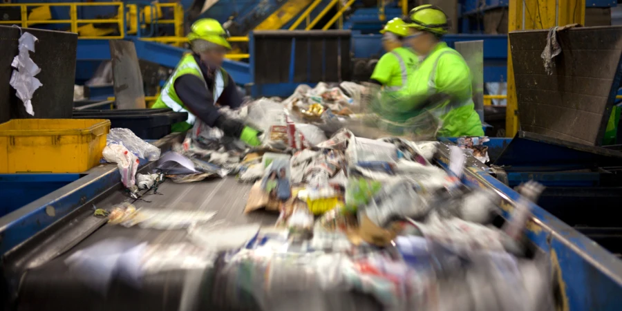Workers separating paper from plastic in a conveyor belt