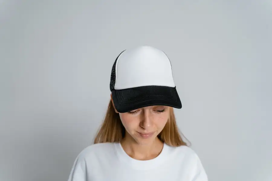 Wanita muda mengayunkan snapback putih dan hitam