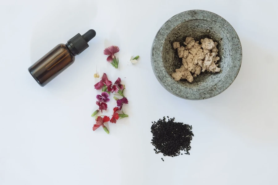 A bottle on a table with herbs