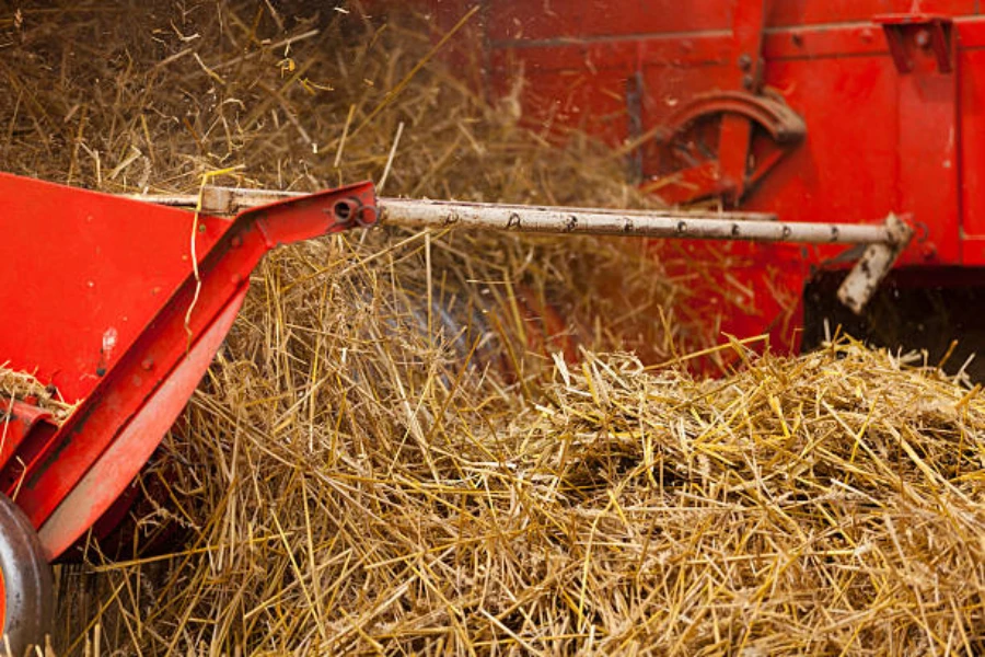 A close-up of a baler making straw bales