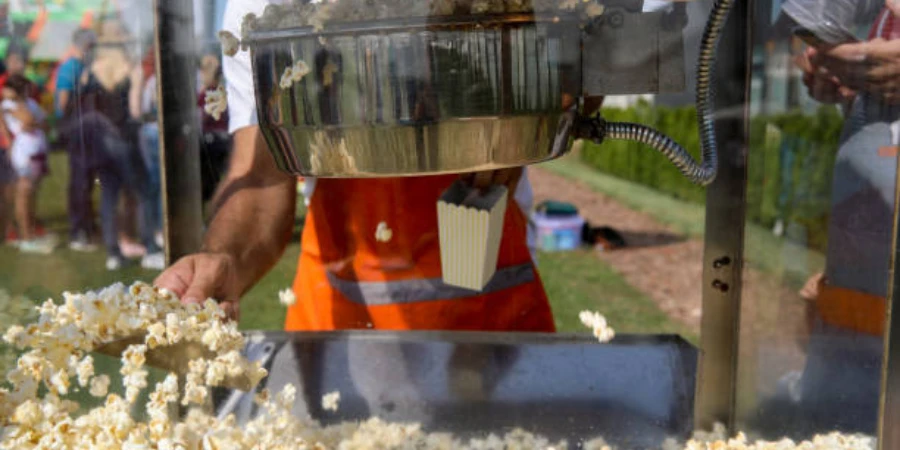 A man making popcorn with a machine