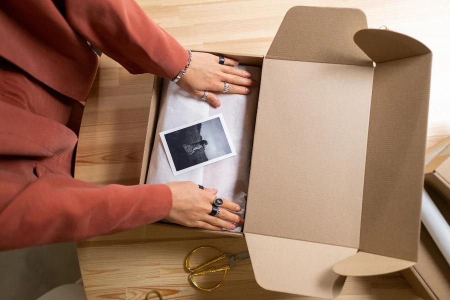 Una persona empacando ropa en una caja.