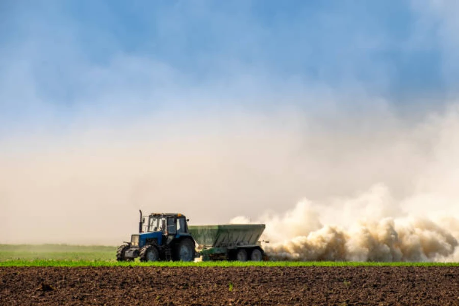 Um trator pulverizando fertilizante no solo