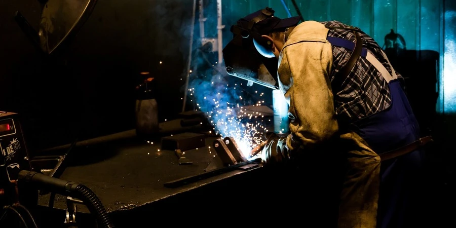 A welder working with a machine