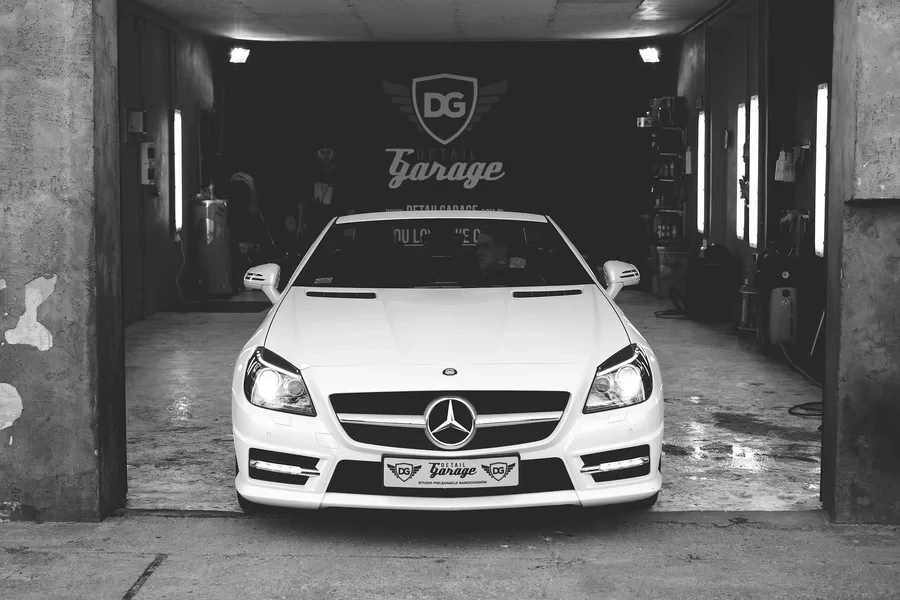 A white Mercedes parked in a garage