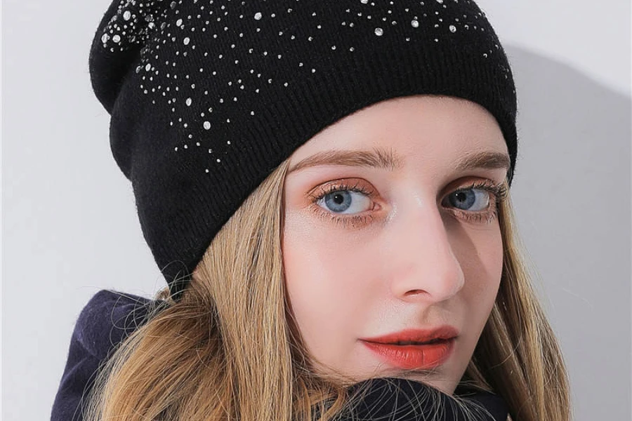 A woman wearing a black knit beanie embellished with rhinestones