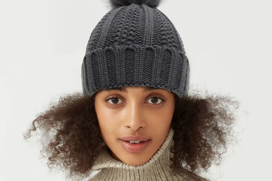 A woman wearing a dark gray wide cuff knit beanie