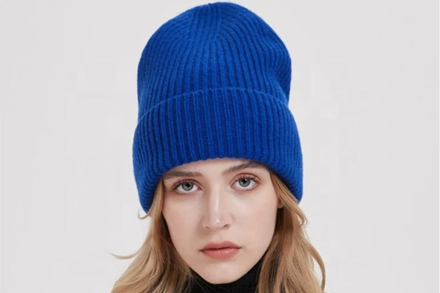 A woman wearing a royal blue knit high-top beanie