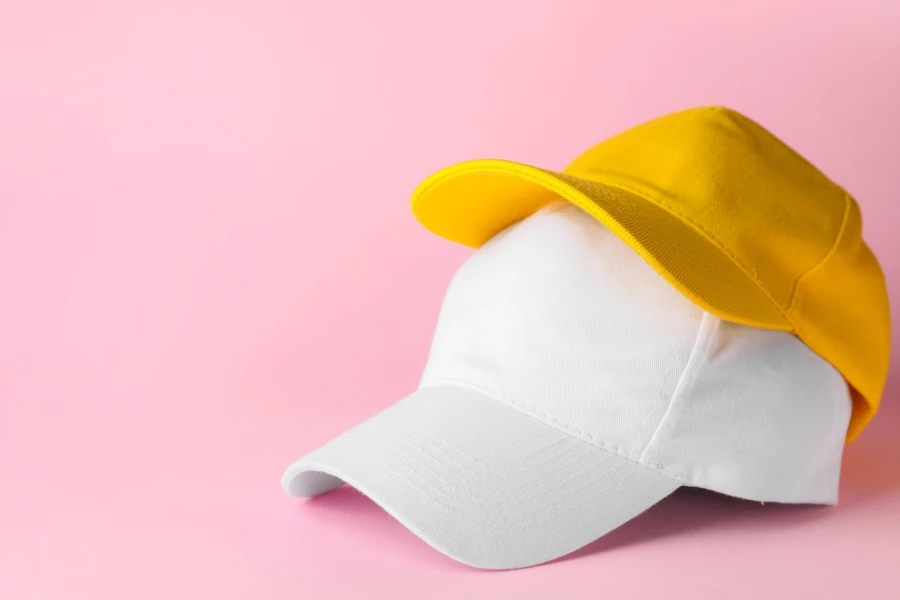 A yellow baseball cap and white baseball cap