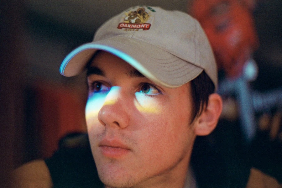 Boy wearing tan baseball cap with embroidered logo