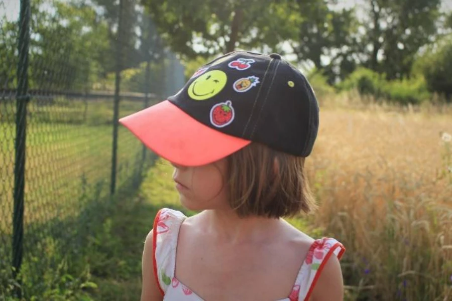 Child in black and red cap with custom patches