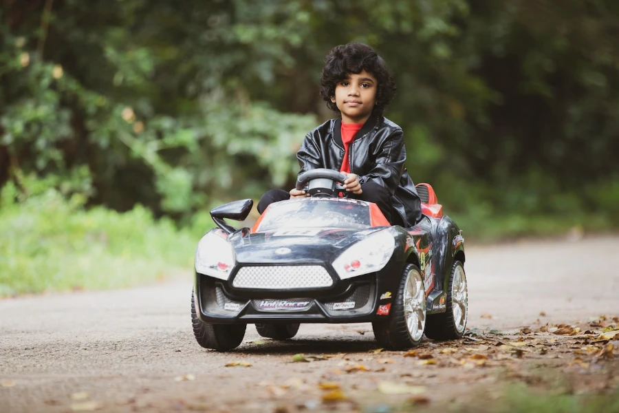 Child playing in a black toy car