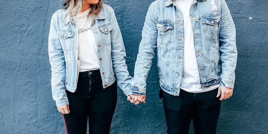 Couple holding hands while rocking denim jackets