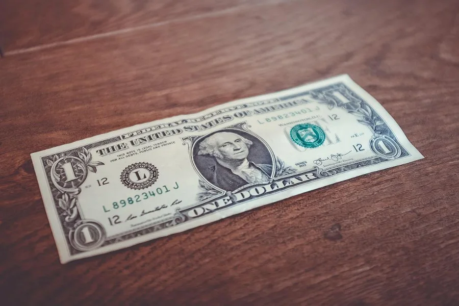 Dollar bill sitting on a dark wooden table