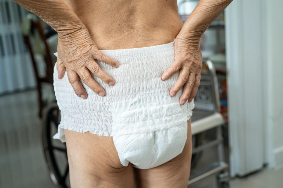 Elderly woman wearing adult diapers while holding waist