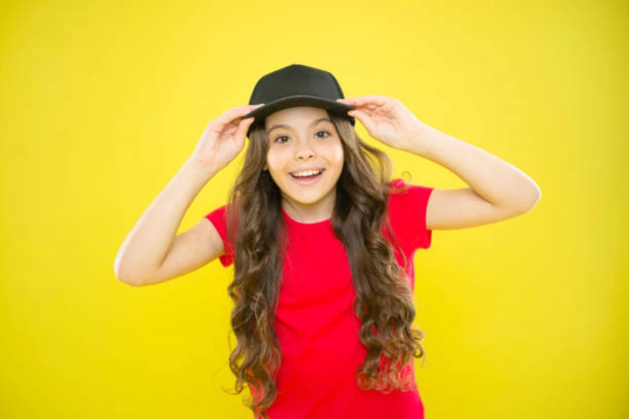 Girl wearing black 5 panel baseball cap and red shirt