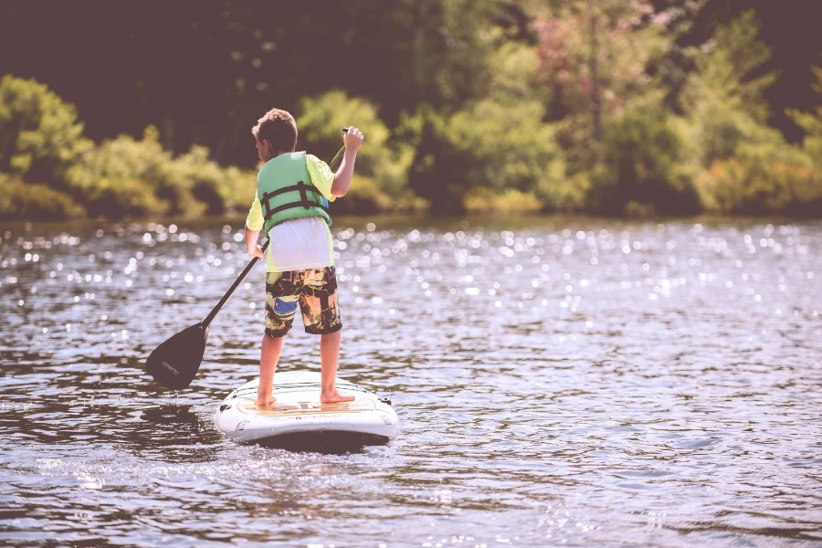 Garotinho em uma prancha de stand-up paddle