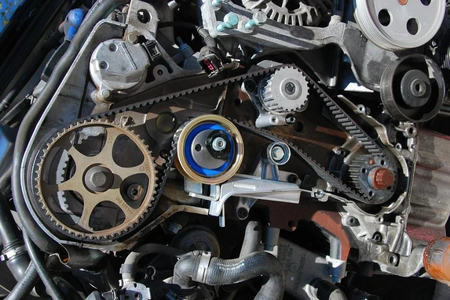 Long timing belt surrounding many engine gears and shafts