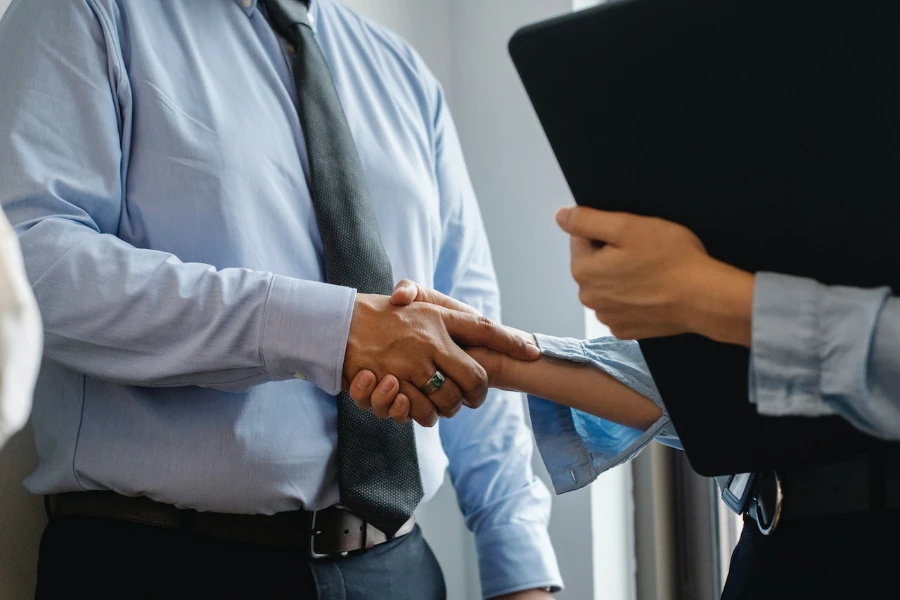 Homme et femme se serrant la main au bureau