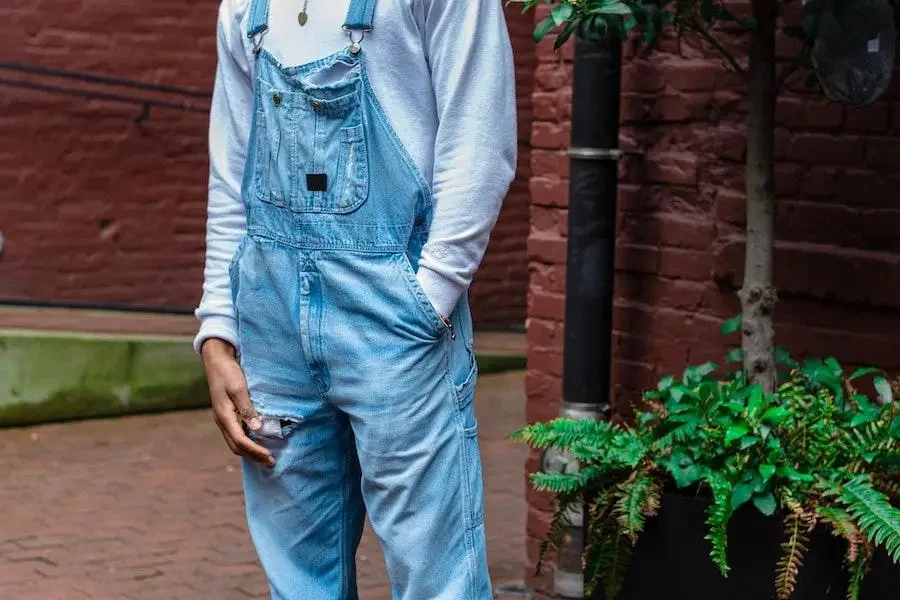 Man rocking a light-wash denim overall and white long sleeves
