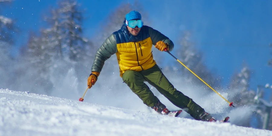 Man skiing in a multi-colored jacket and mask