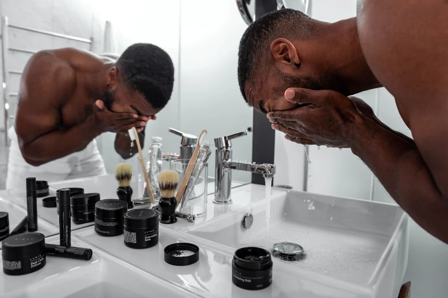 Homme se lavant le visage dans la salle de bain