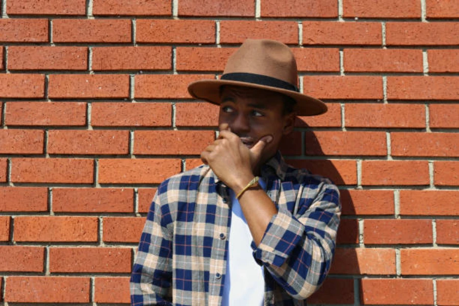 Man wearing brown fedora hat with black ribbon around it