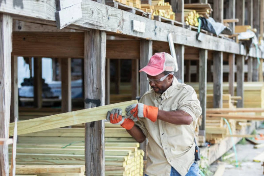 Man wearing trucker cap while examining wood