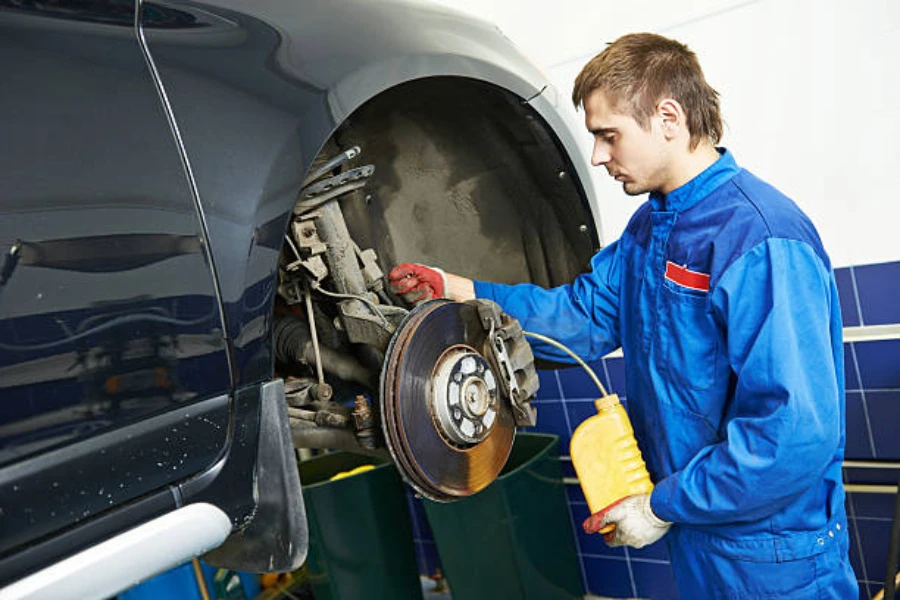 Mechanic working to replace brake fluid in a car