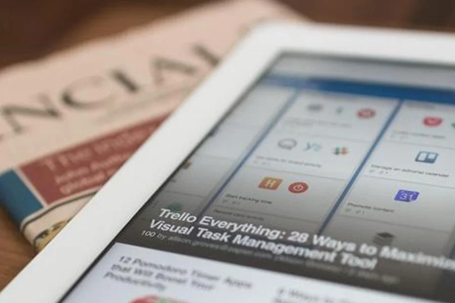 News headline on tablet with newspaper under it