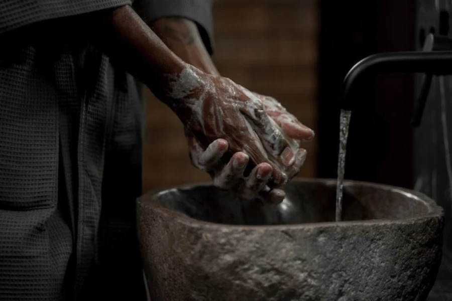 Person washing their hands in a stone wash basin