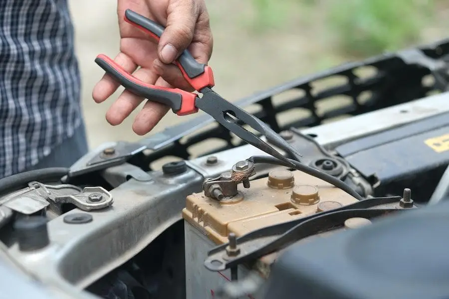 Personne travaillant sur une batterie de voiture