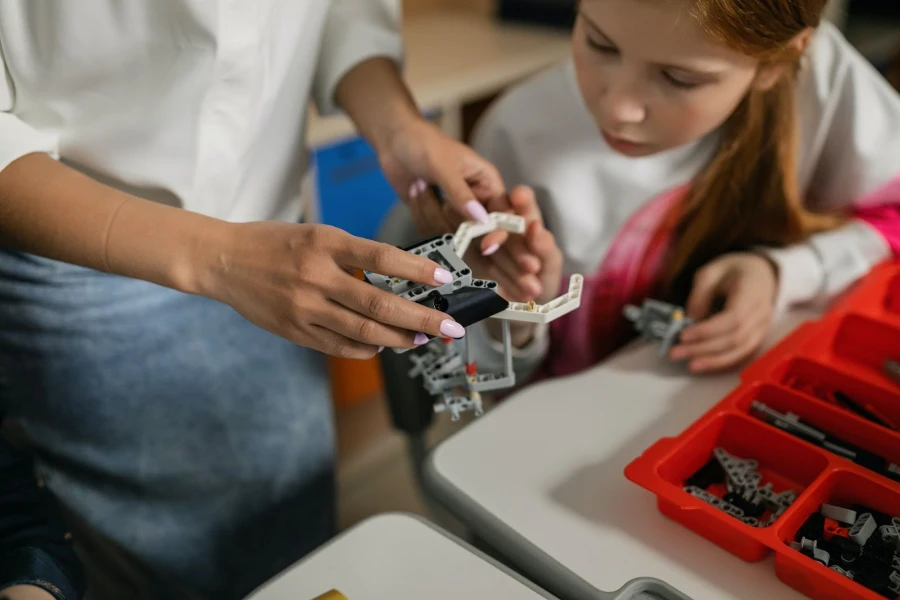 Aluno e professor personalizando um brinquedo robótico