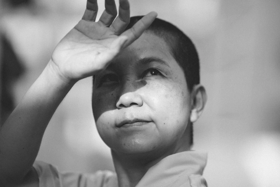 Senior Asian woman covering her face from the sun