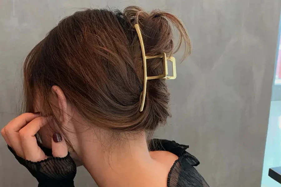 Thin gold metal hair claw clip on brown hair